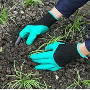 Deux mains en gants plantant des jeunes pousses dans la terre pour la plantation ou le jardinage.